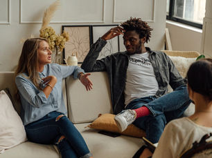 A couple engaging in an emotionally intense discussion during a therapy session, with a therapist attentively observing—depicting the challenges and dynamics of modern couples therapy.
