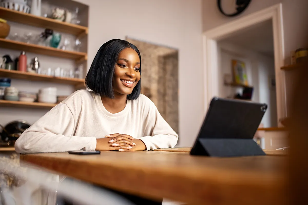 Smiling woman attending an online therapy session on a tablet, showing the positive experience of virtual counseling in 2025.