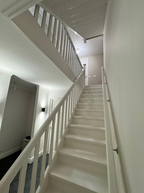 Schilder in Almelo bezig met muren en plafonds schilderen voor een woning.