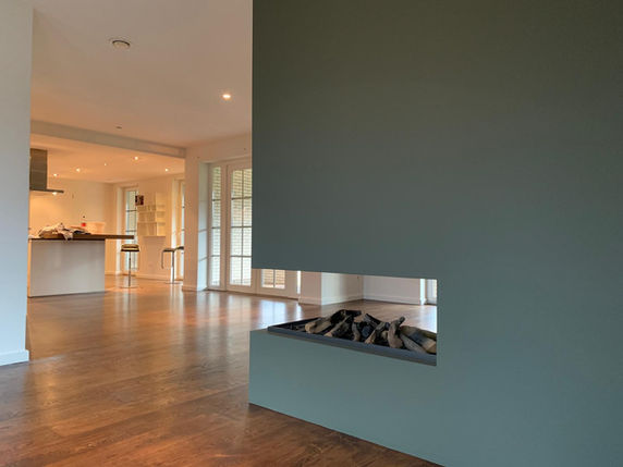 Schilder in Almelo bezig met muren en plafonds schilderen voor een woning.