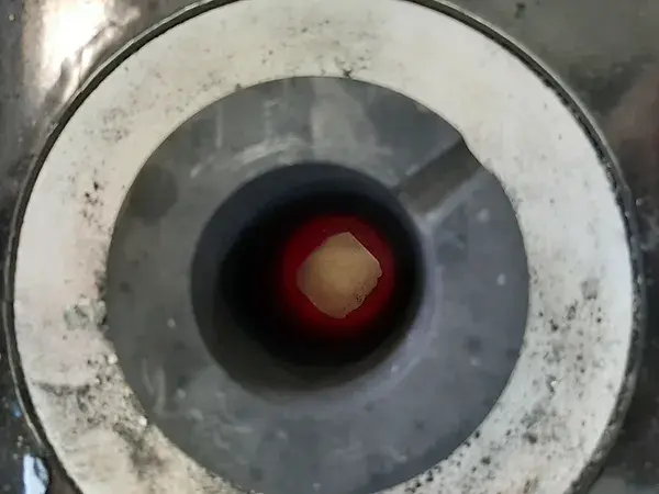 Crucible containing a ceramic heated to high temperature for optical temperature measurement tests with a ThermoRef sensor.