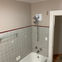 Freshly painted bathroom with grey tile and white tub