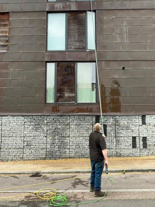 Window cleaner working outside a stone-fronted building