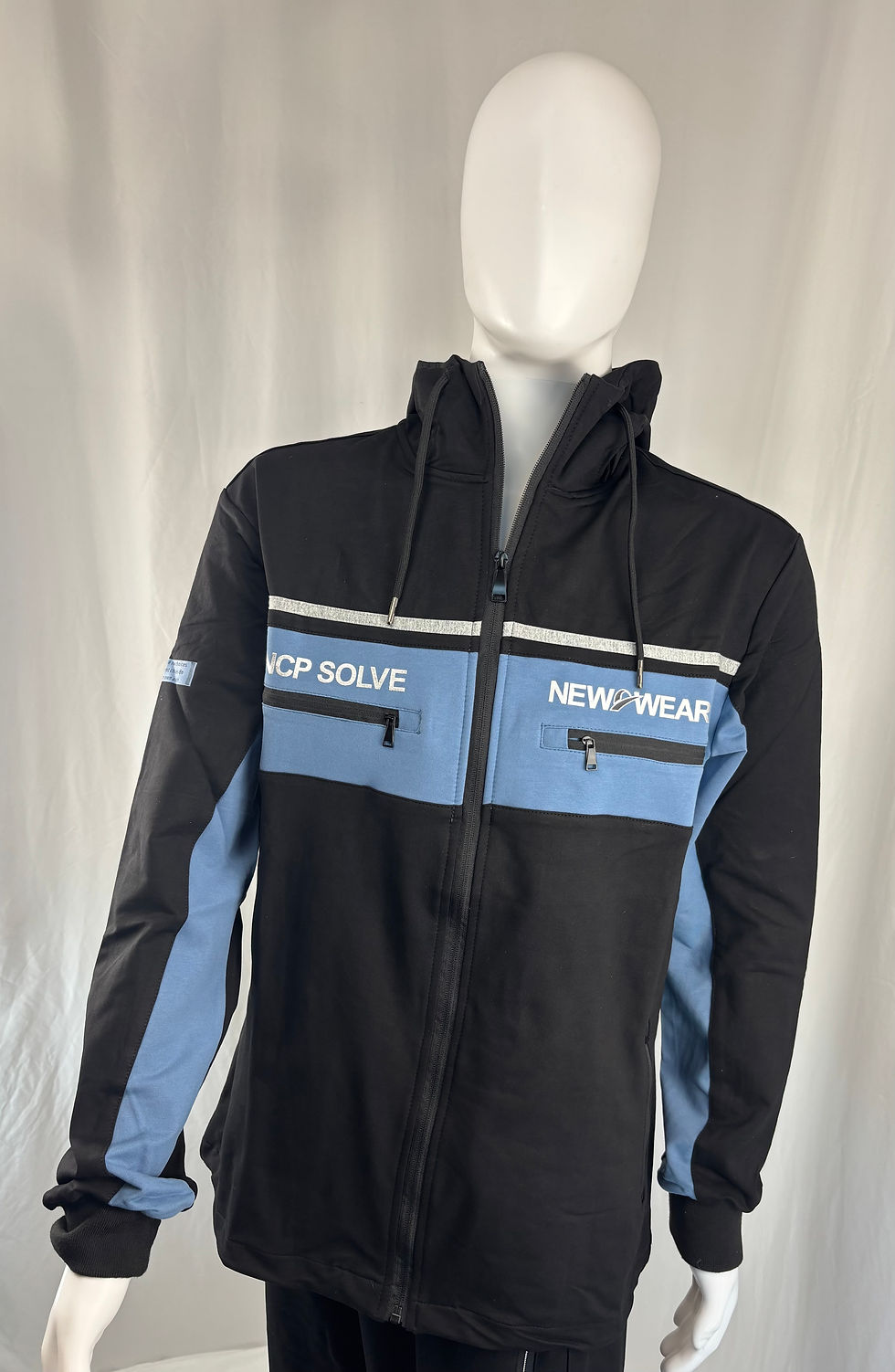 Front view of NCP Solve black and blue colorblock hooded windbreaker jacket with chest pockets and graphics.