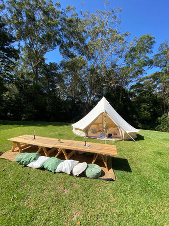 IMG_4036.Picnic Table with Decorations and cushions with a bell tent in a backyard