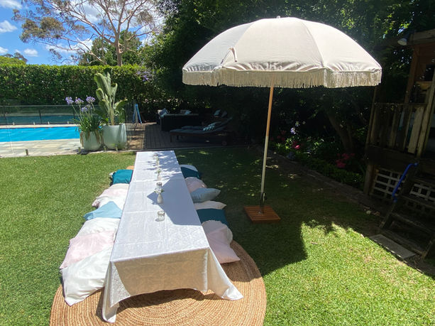 Picnic Table with decorations and umbrella shade in a backyard