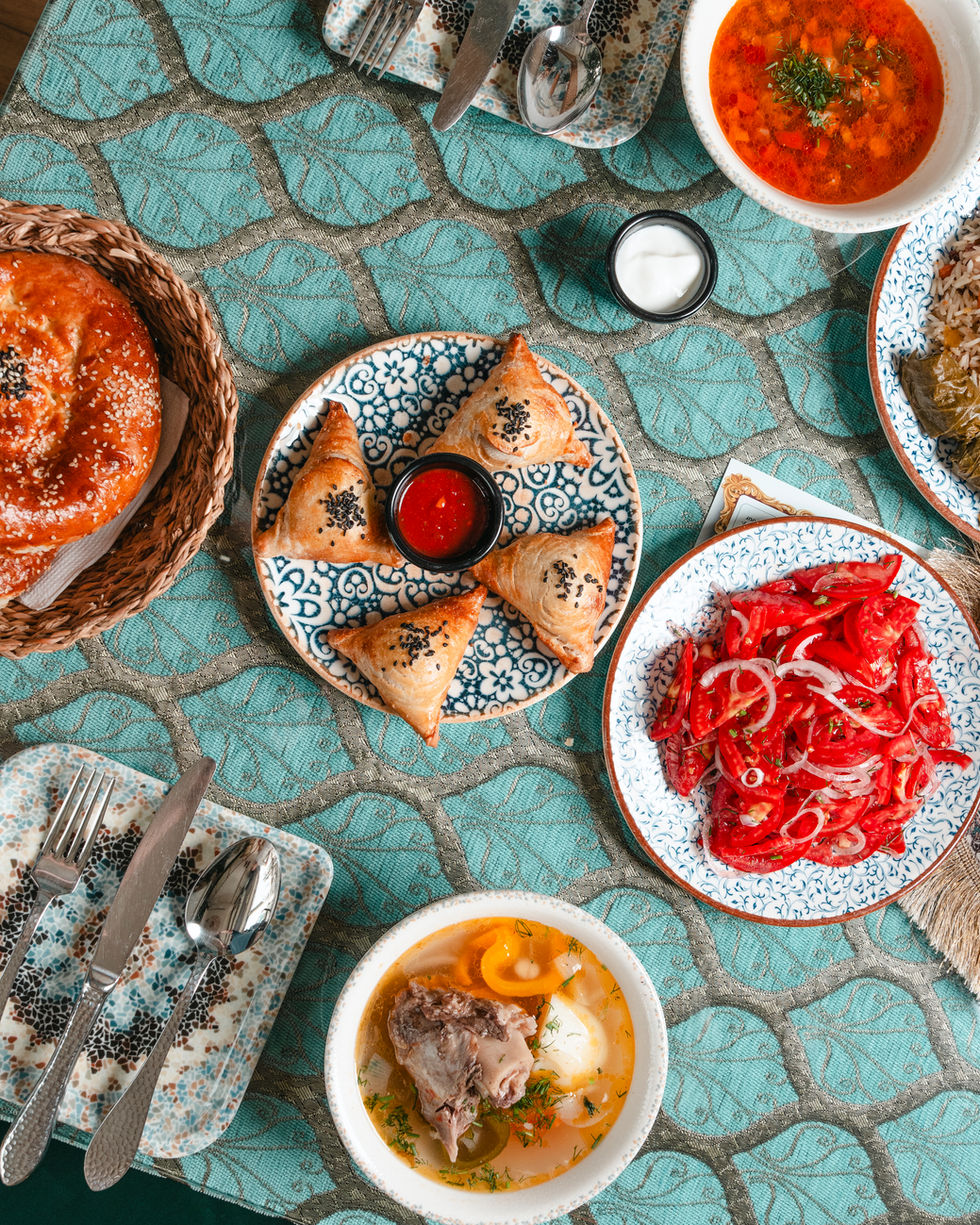 Full dinner table setup featuring Middle Eastern dishes and side plates