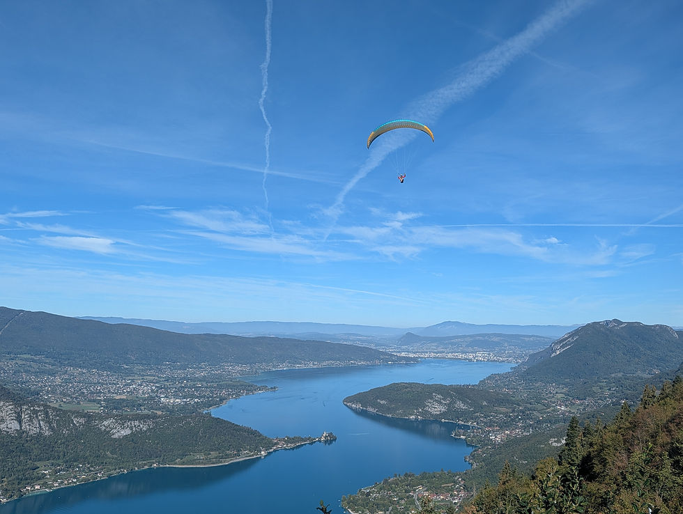 ThParaglider descending over Lake Annecy viewed from the Col de Forclaz climb