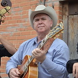Joey McKenzie, bandleader for The Western Flyers Western swing band holding a vintage gibson guitar