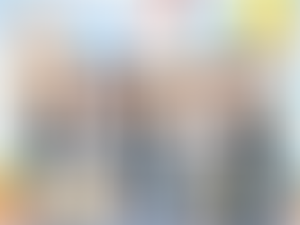 Cartoon of five people in business attire shaking hands on a stage. Symbols of a rocket, globe, and lightbulb in the sky suggest creativity.