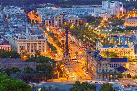 Aerial view over square Portal de la pau and Port Vell marina and Columbus Monument at nig