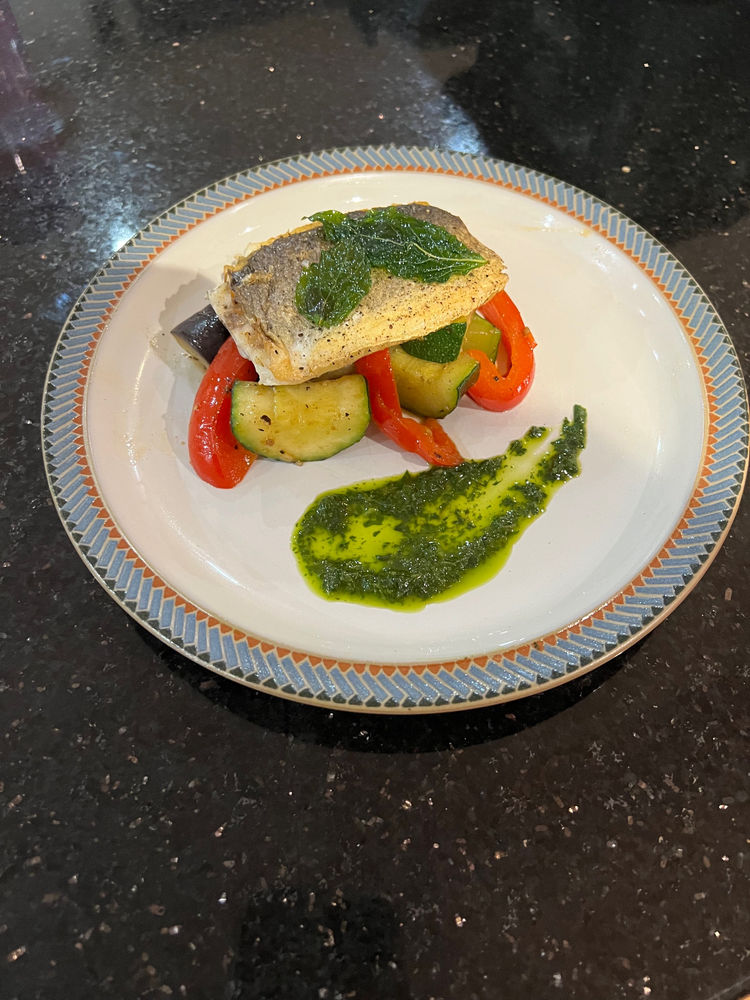 Sea bass served with ratatouille, crispy basil leaves and basil oil