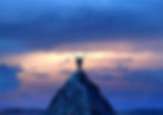 image représentant une personne qui se tient debout sur une montagne ou une colline, les bras levés en signe de réussite et d'accomplissement