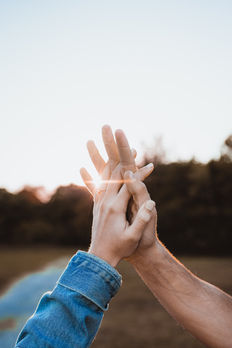 Couple holding hands up towards sky