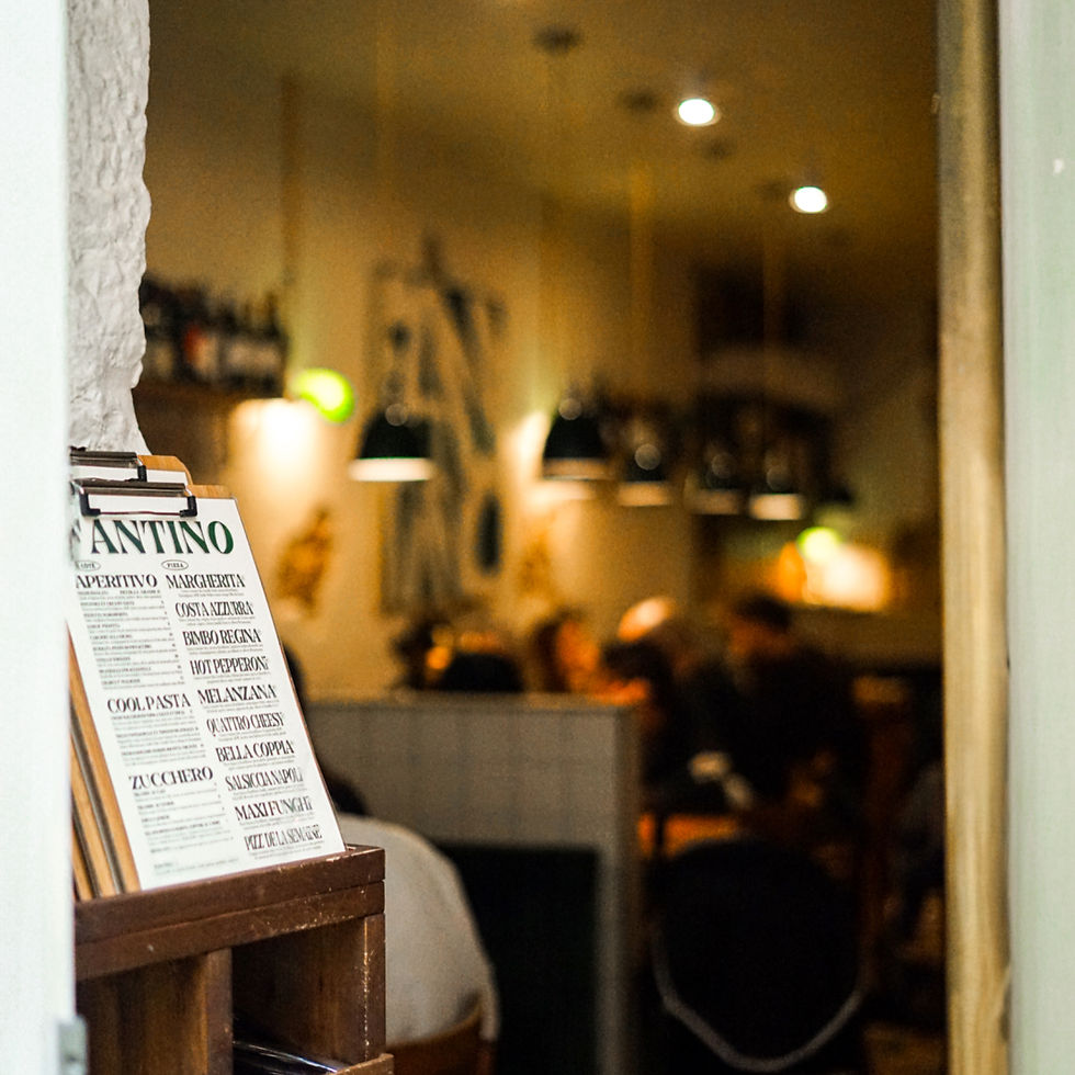 Menu Fantino devant une pizzeria chaleureuse, avec plats italiens visibles et lumières tamisées.