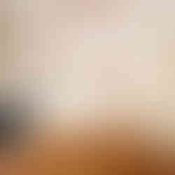 Cuisine sur mesure dans un appartement haussmannien rénové à Paris, façades beige clair, étagère en bois et électroménager intégré.