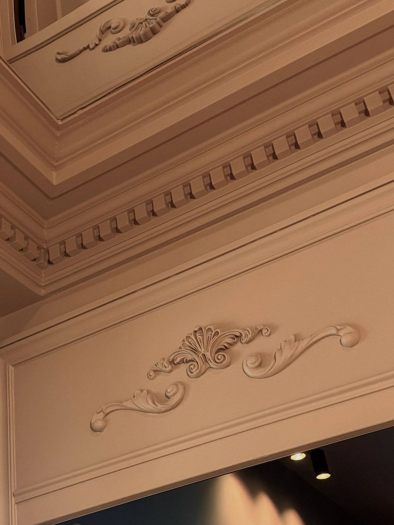 Détail de moulures décoratives au-dessus d’une porte dans un espace de bureaux à Paris