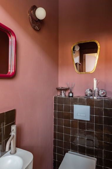 WC avec enduit terracotta profond, carrelage brun glacé et miroirs irréguliers — architecture d'intérieur Studio Castille