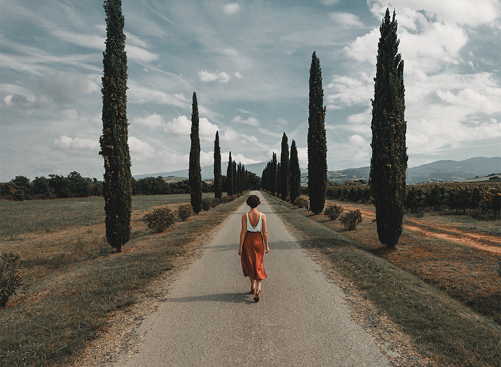 Leading lines photography example, woman walking up a street with trees