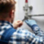 Over the shoulder image of a plumber fixing a pipe.jpg