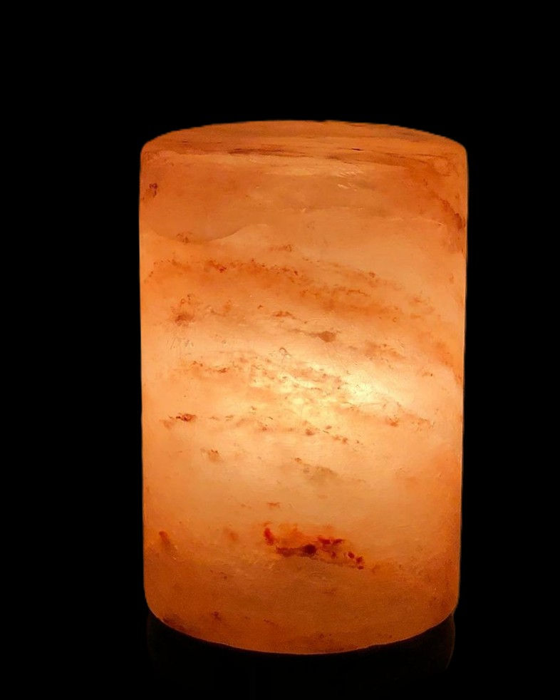 Glowing orange cylindrical Himalayan salt lamp against a black background, emitting a warm, ambient light with subtle texture and natural patterns.