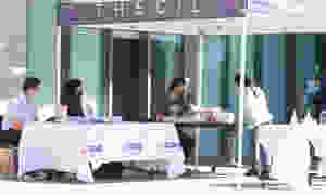 People outside around two tables.