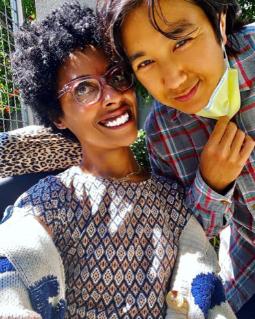 Two people, Giovana and Pua, next to each other taking.a selfie outside.