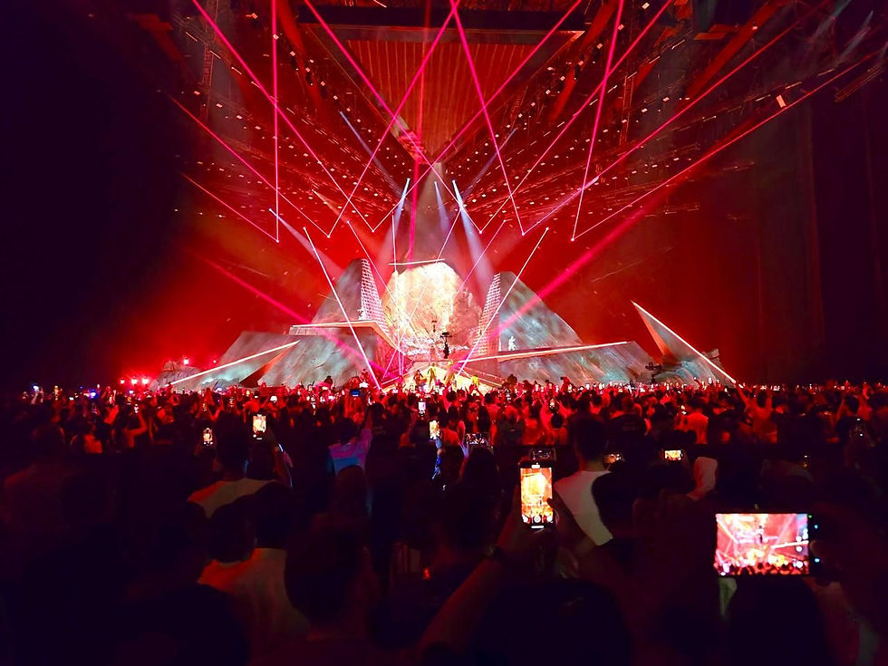 Wide landscape photo of an immersive esports exhibition stand with bold lighting and LED screens, strong red and green accents, and a futuristic environment.