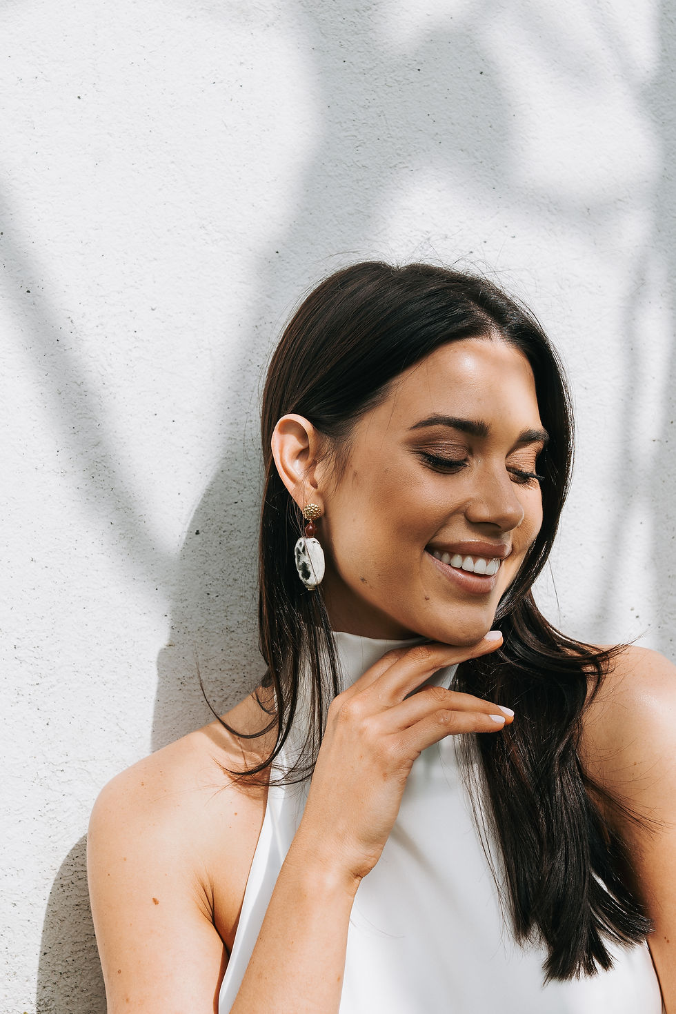 Thumbnail: Model wearing ceramic drop earrings with patterned statement bead