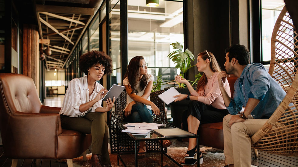Informal group of four weighing a decision in co-working lounge