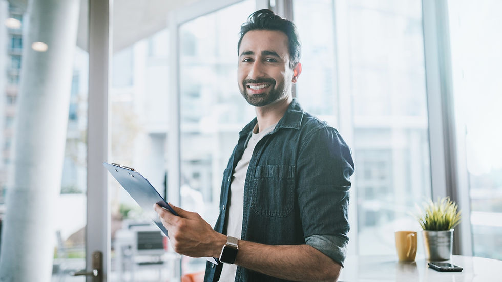 Smiling man with clipboard in bright office - asset inspection