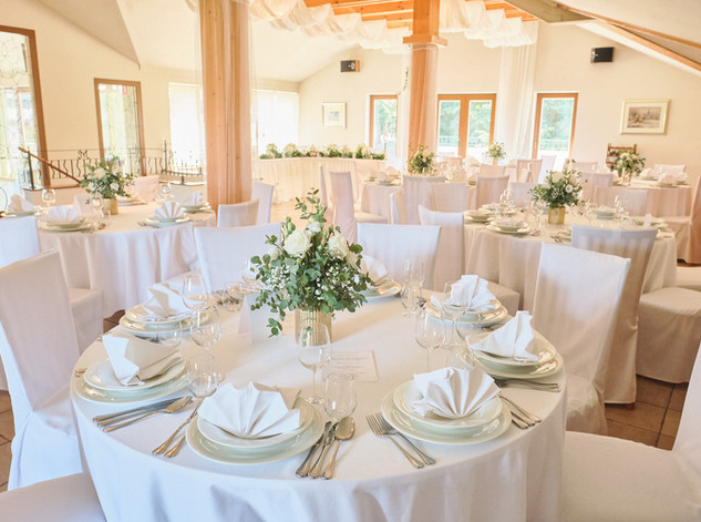 Wedding hall at Mamica restaurant with white tablecloths and floral decorations