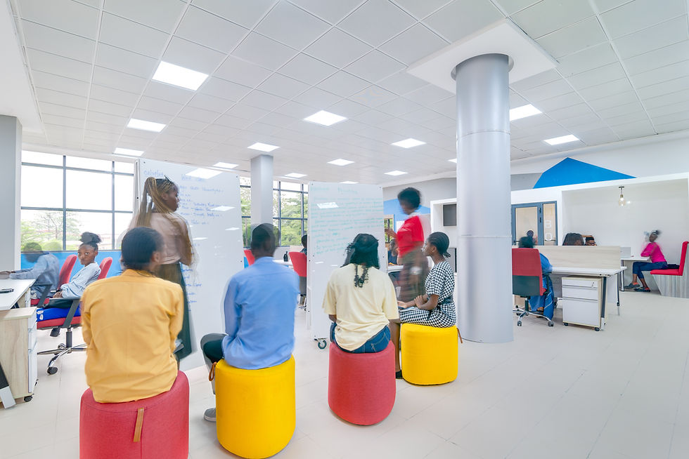 Students working together and socializing in a vibrant co-learning space at the LASU Innovation Hub, featuring collaborative seating, murals, and natural lighting.