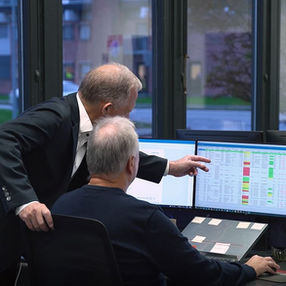 To personer gennemgår information på en computerskærm