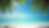 Eye-level view of a tropical beach with clear blue water and palm trees