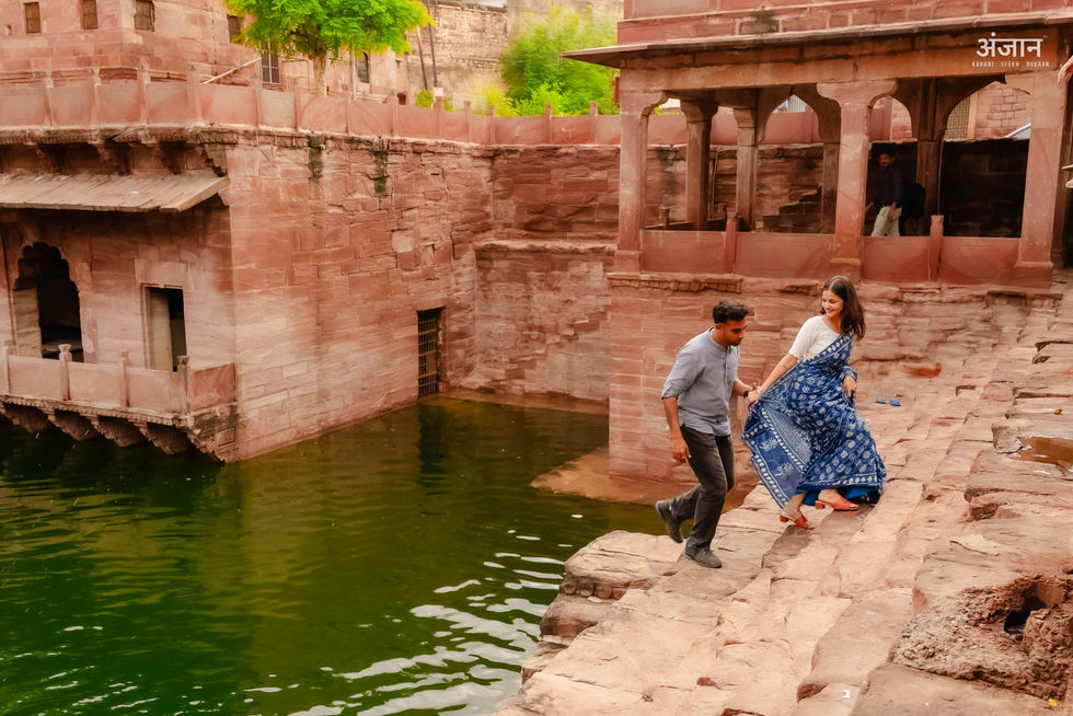 Couple sitting on Toorji Ka Jhalra steps Jodhpur