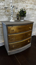 This piece has a nice whitewashed finish with aged patina gold leaf on the drawers of the dresser.