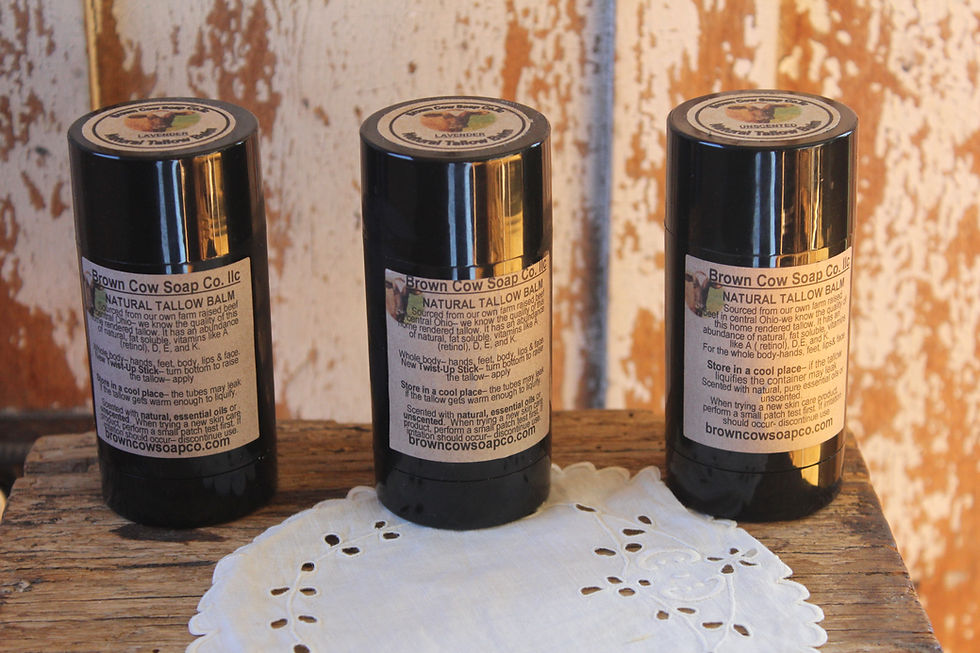 three tubes of scented tallow balm with jojoba on a table