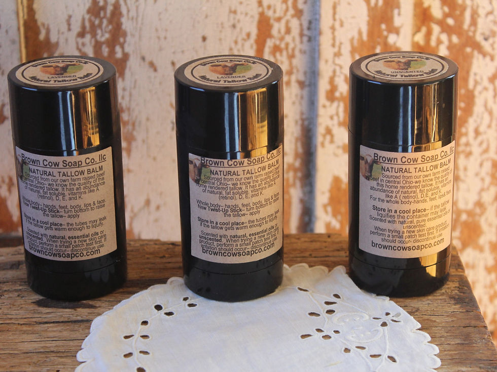 three twist up tubes on a table with brown cow soap labels with tallow balm