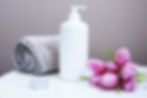 white plastic pump bottle beside pink tulips and gray towel_edited.jpg