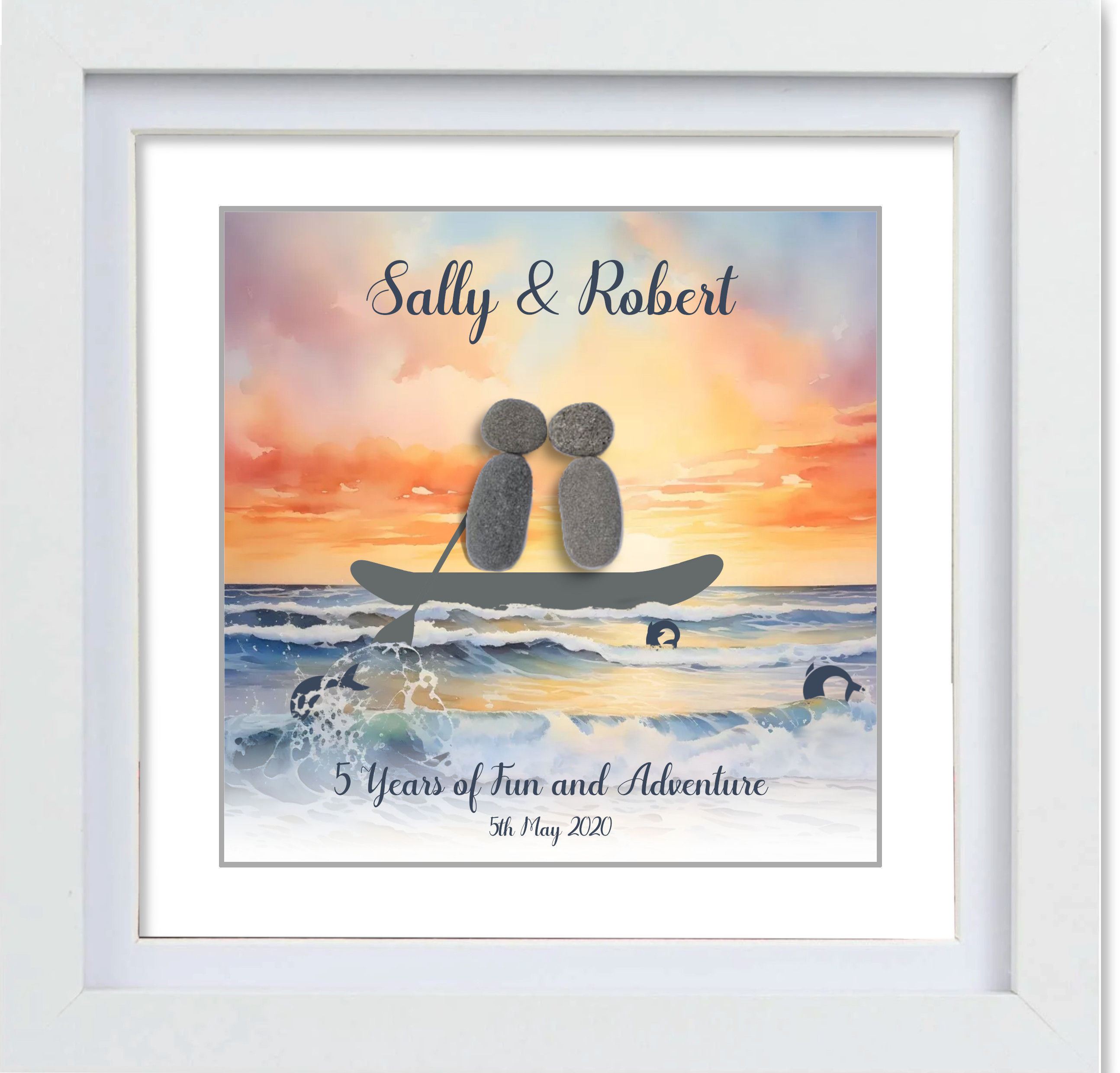 Pebble Couple sitting on a paddleboard boat in the ocean with a sunset behind