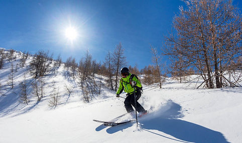 skier in powder snow in the Val d'Allos resort, blue sky and sun, location of the hamlet hotel