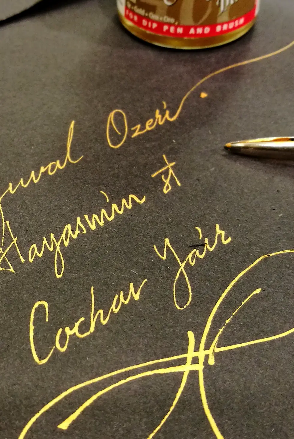 כתב קליגרפי בדיו זהב על גבי מעטפה שחורה - יורם קפלן