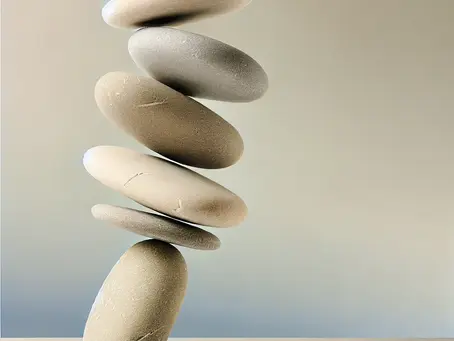 A vertical stack of smooth stones balancing delicately, symbolizing the dynamic and integrated nature of work-life balance as a portfolio of interconnected priorities.