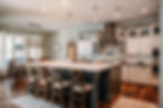 Spacious and elegant kitchen with a large island, modern pendant lighting, and stylish cabinetry, featuring comfortable seating and a well-lit cooking area.