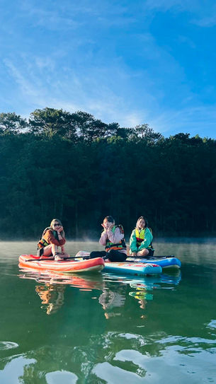 Kayaking on a misty lake in Dalat at sunrise, surrounded by pine forests, a peaceful outdoor adventure near Dalat Train Village.