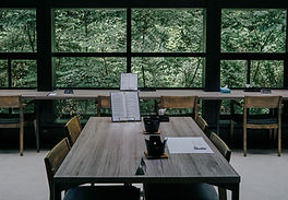 A board room table with windows looking out into trees