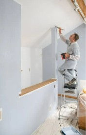 Professional painter applying paint at the edge of a ceiling. Credot: BIll Oxford from Getty Images Signature on Canva Pro