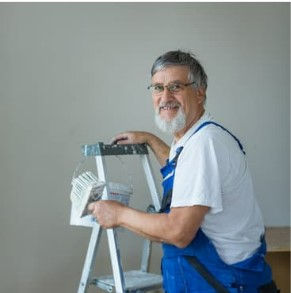 Senior man on a ladder holding a paintbrush. Credit: Viktor Cap from Getty Images on Canva Pro