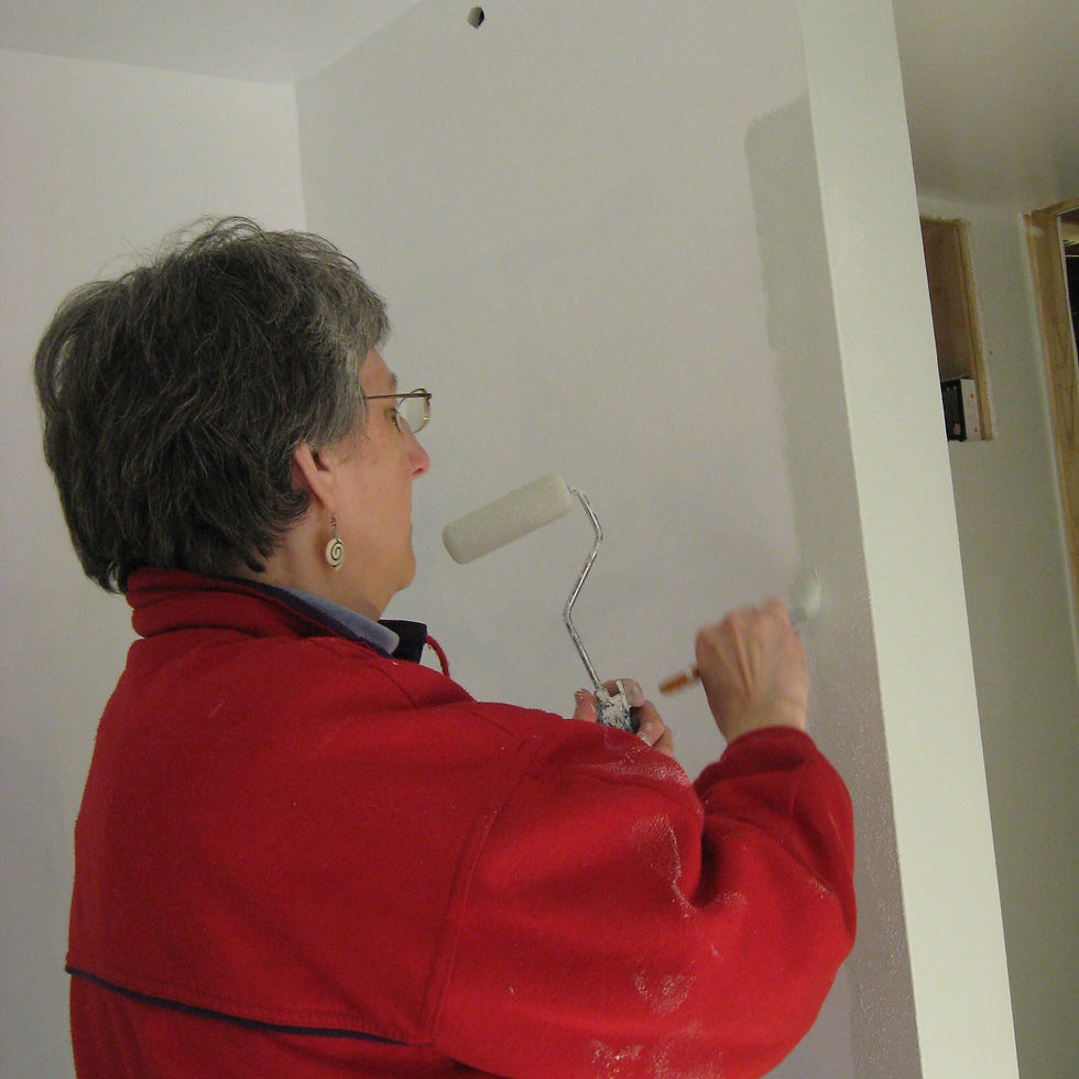 Barb Bickford concentrating on painting a wall. Photo credit: Aralee D